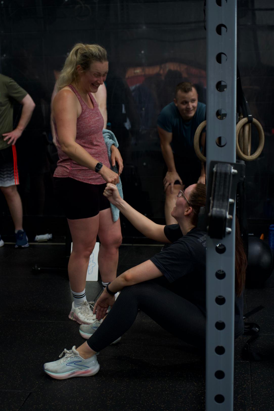 A coach kneeling to help a member mid session
