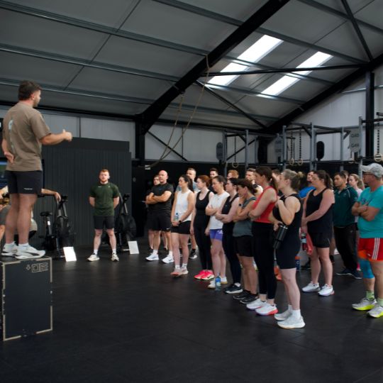 Coach briefing the class from the box at the start of a session
